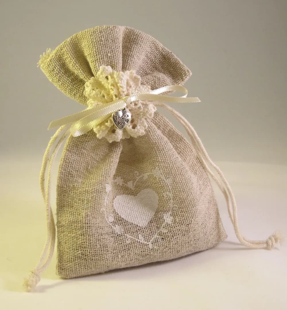 Pochon en toile de lin à cordon, orné d'un cœur blanc, d'une fleur en dentelle, d'un ruban crème et d'une breloque « Thank you »